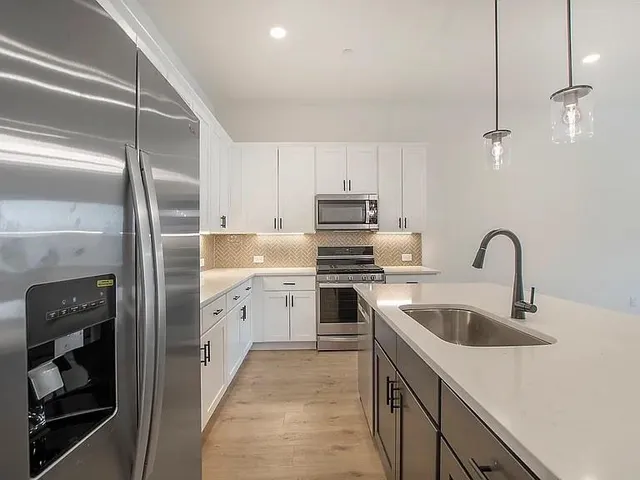 a kitchen with a sink appliances and cabinets