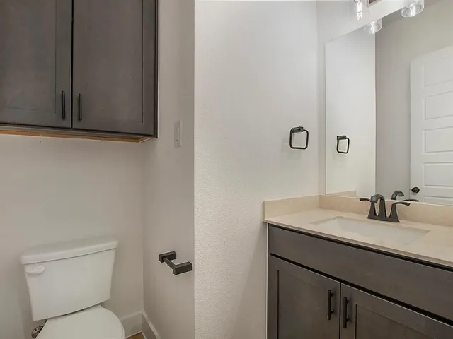 a bathroom with a sink toilet and mirror