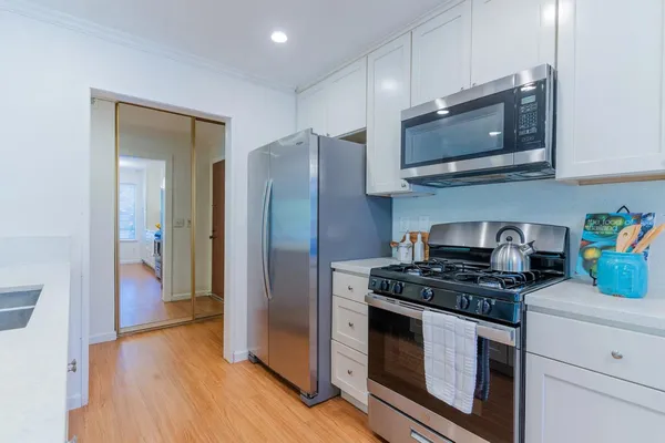 a kitchen with stainless steel appliances granite countertop a stove microwave and refrigerator