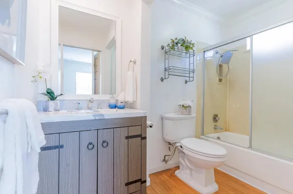 a bathroom with a granite countertop sink toilet a large mirror a shower and a bathtub