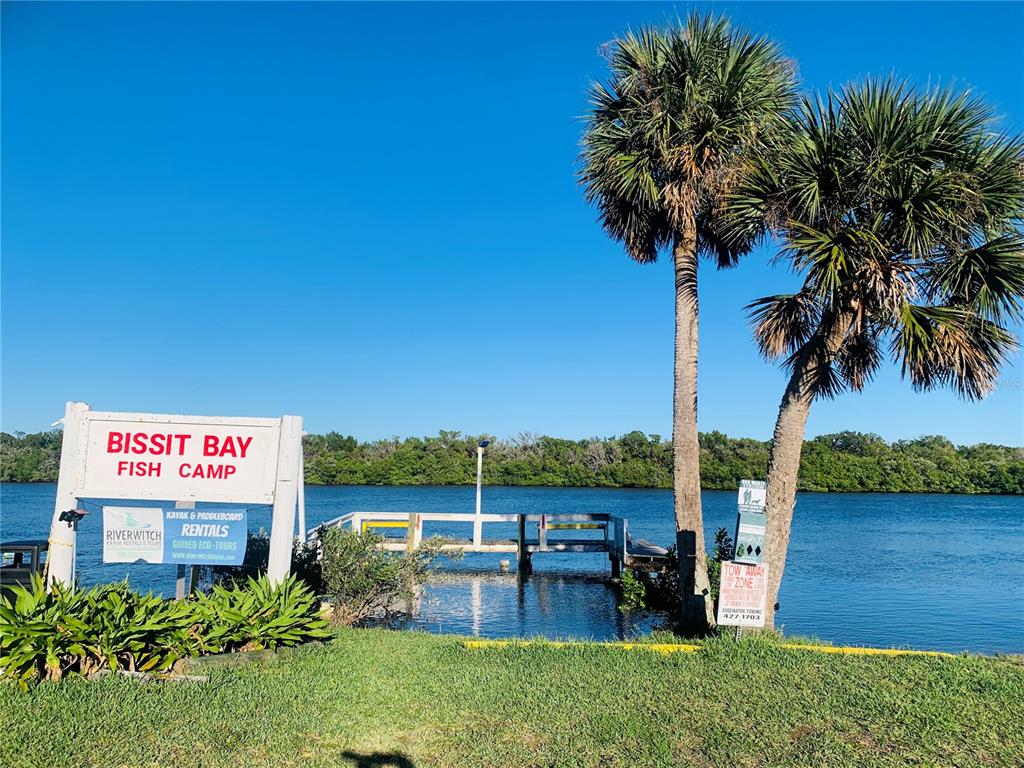 251 Bissit Bay Road Oak Hill, FL 32759 - Photo 1 of 9 a sign that is sitting on a wooden floor next to a lake