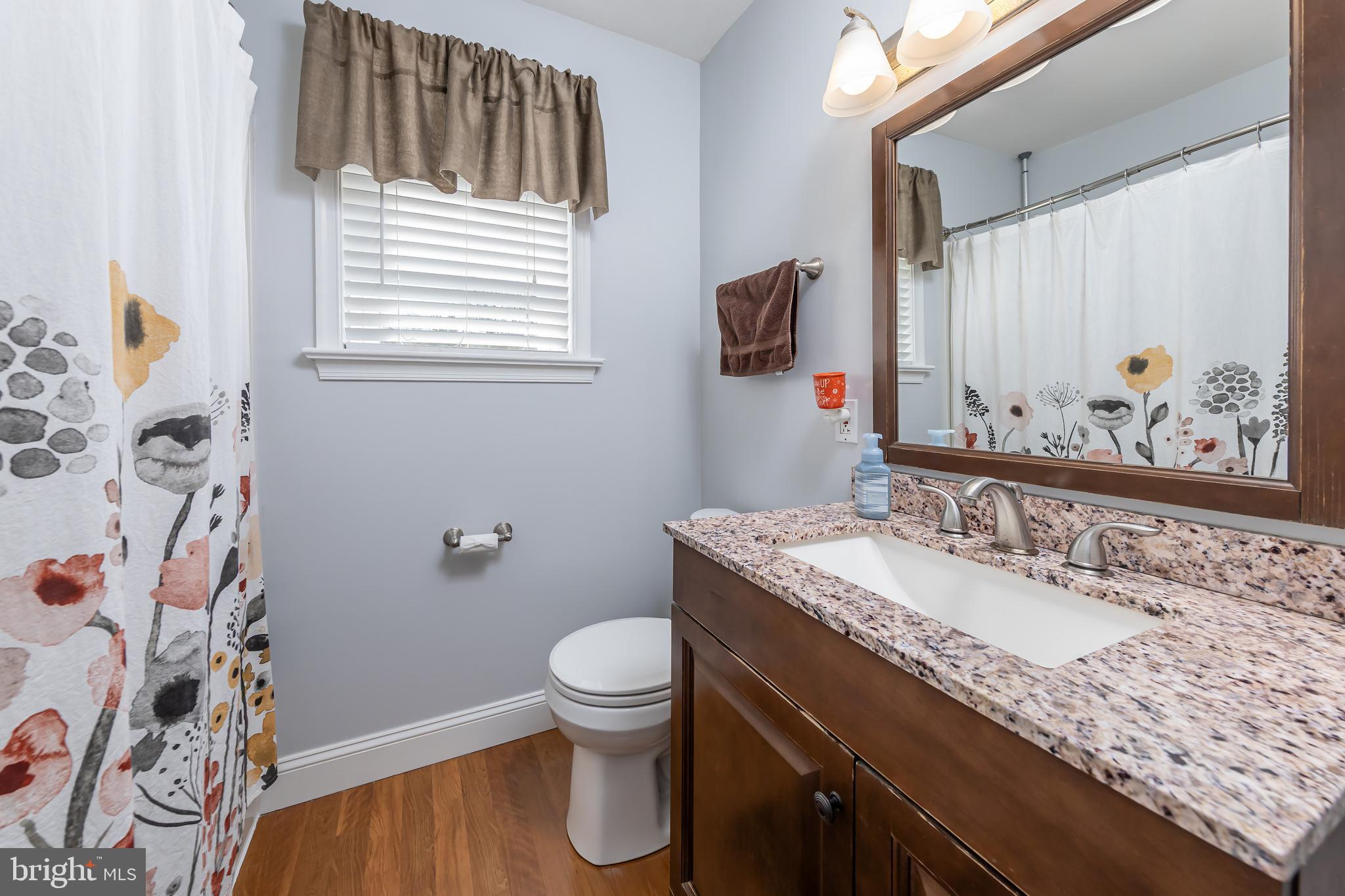 303 Main Street Mantua, NJ 08051 - Photo 19 of 48 a bathroom with a granite countertop toilet sink and mirror
