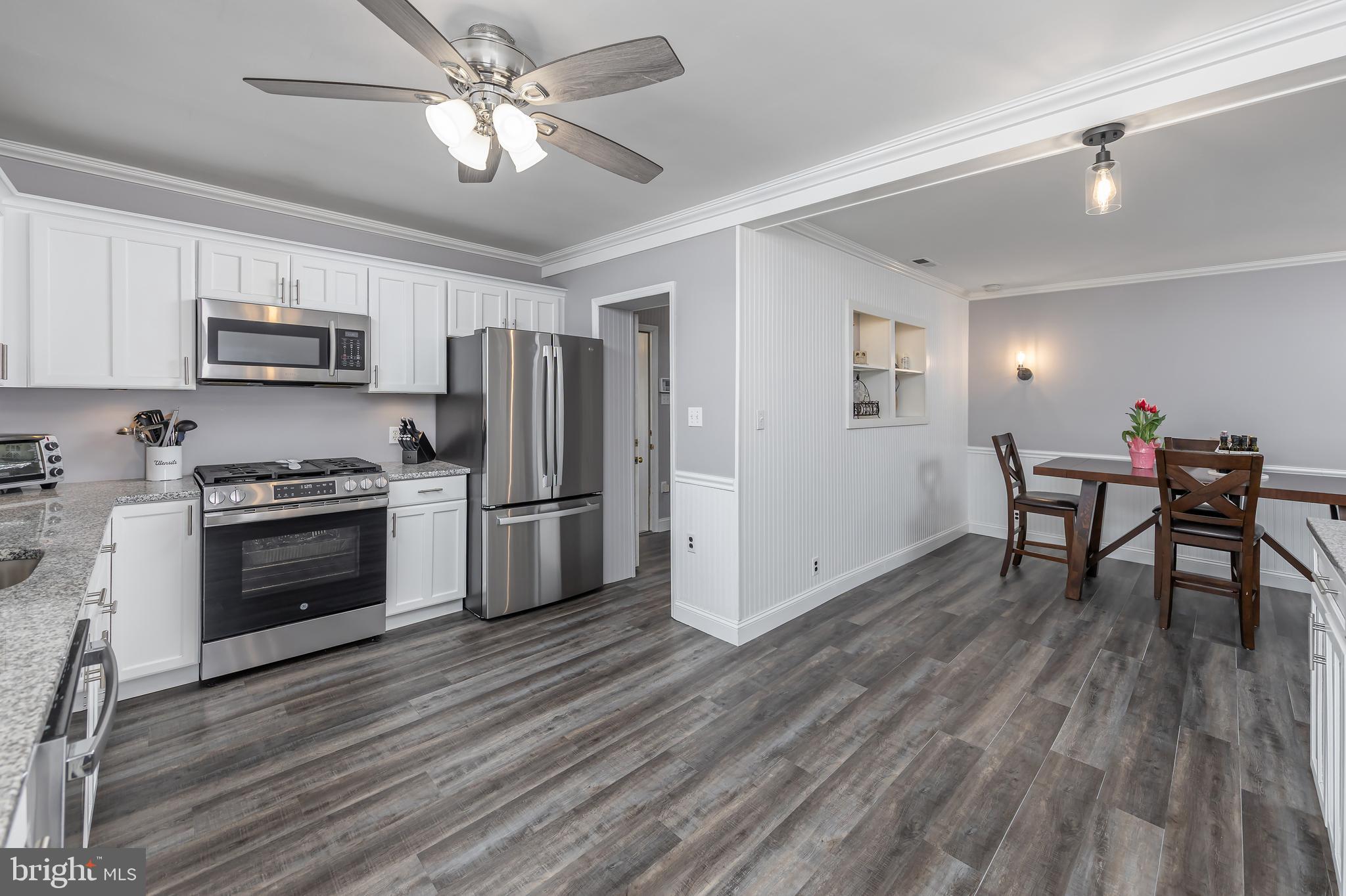 303 Main Street Mantua, NJ 08051 - Photo 6 of 48 a kitchen with stainless steel appliances a stove top oven a refrigerator cabinets and a dining table