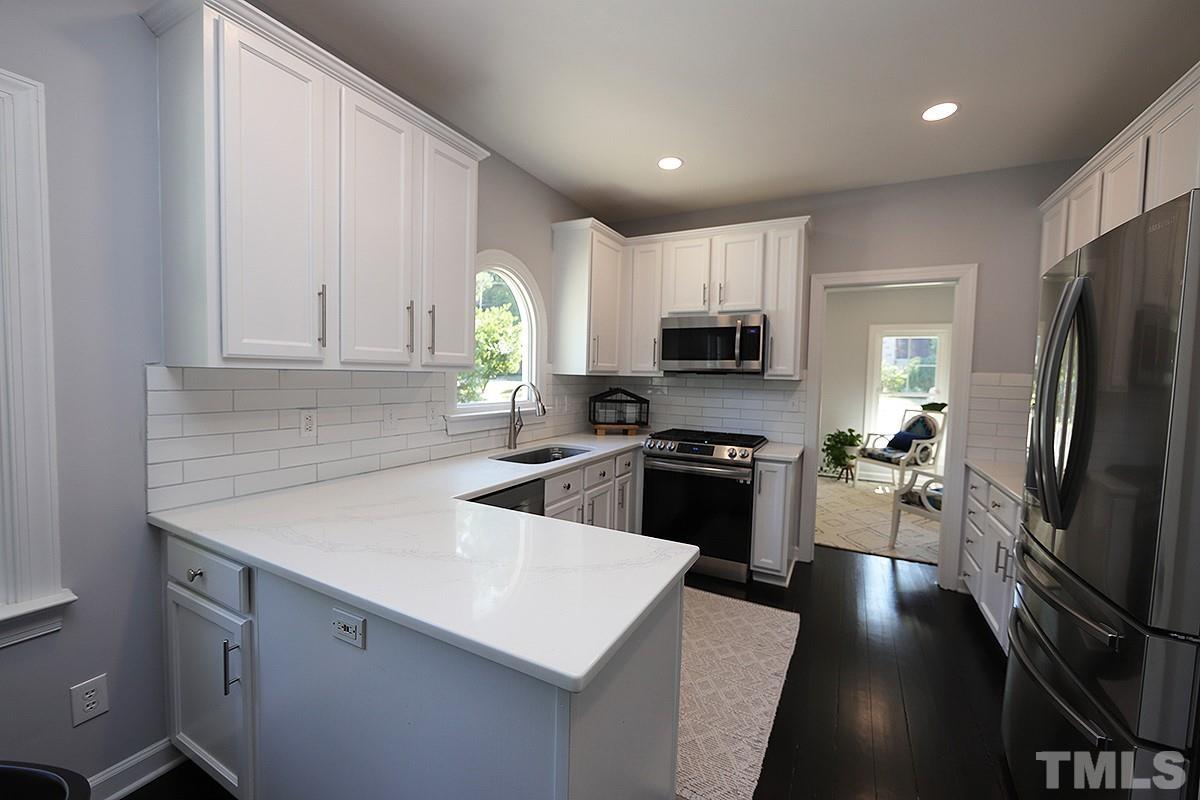 3715 Bellevue Road Raleigh, NC 27609 - Photo 5 of 15 a kitchen with a sink a counter top space cabinets stainless steel appliances and a window