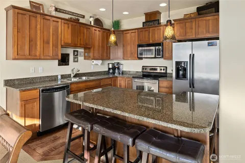 a kitchen with stainless steel appliances granite countertop a stove a sink and a microwave