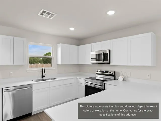 a kitchen with stainless steel appliances granite countertop a sink a stove a counter space and cabinets