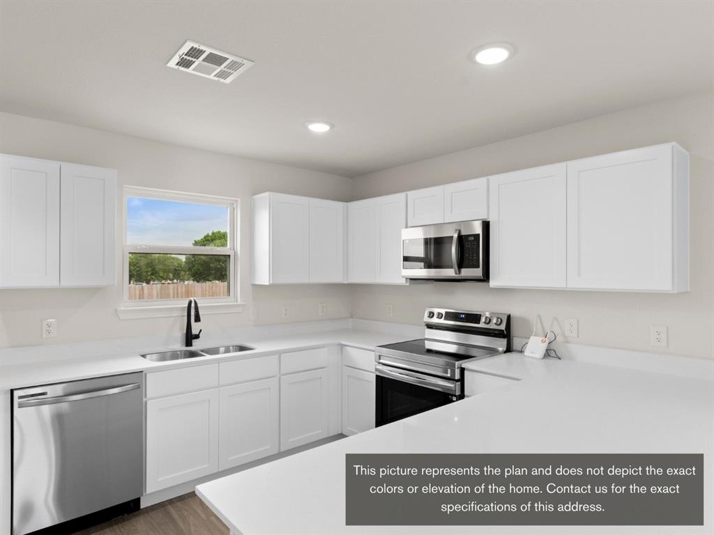 1809 Zelvia Lane Waco, TX 76708 - Photo 11 of 26 a kitchen with stainless steel appliances granite countertop a sink a stove a microwave a refrigerator a white cabinets and wooden floor