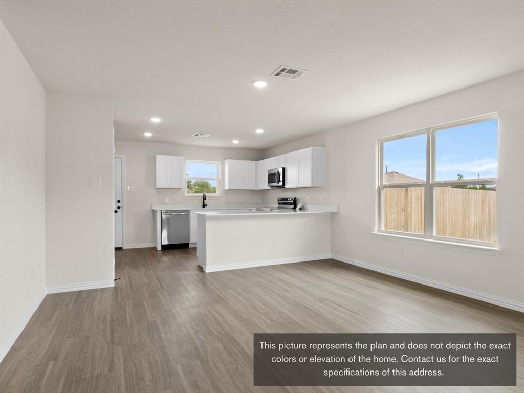 1809 Zelvia Lane Waco, TX 76708 - Photo 7 of 26 a large white kitchen with kitchen island a sink wooden floor and view living room