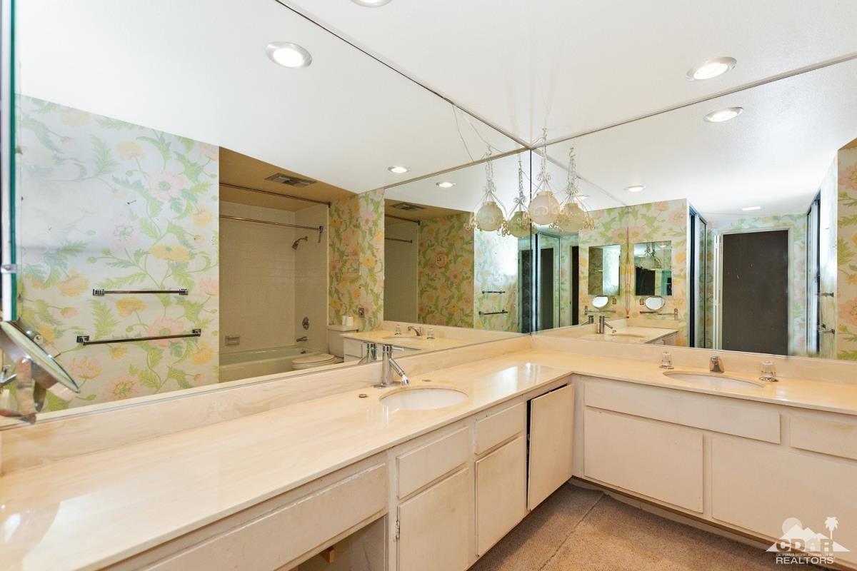 900 Island Drive, Unit 109 Rancho Mirage, CA 92270 - Photo 12 of 19 a bathroom with a sink double vanity and a large mirror