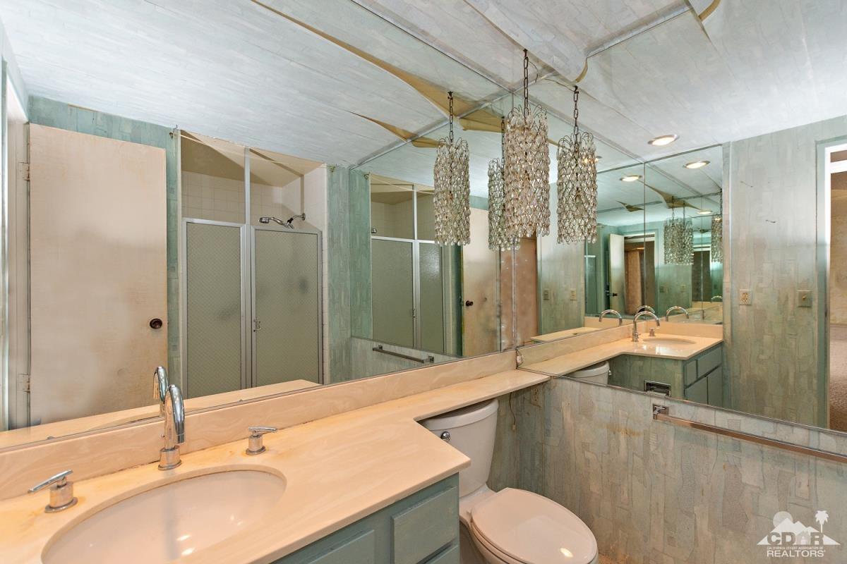 900 Island Drive, Unit 109 Rancho Mirage, CA 92270 - Photo 10 of 19 a bathroom with a sink and mirror with toilet