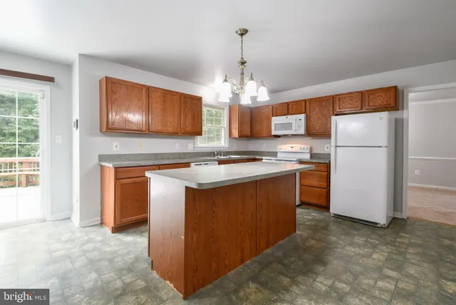 a kitchen with stainless steel appliances granite countertop a stove refrigerator and microwave