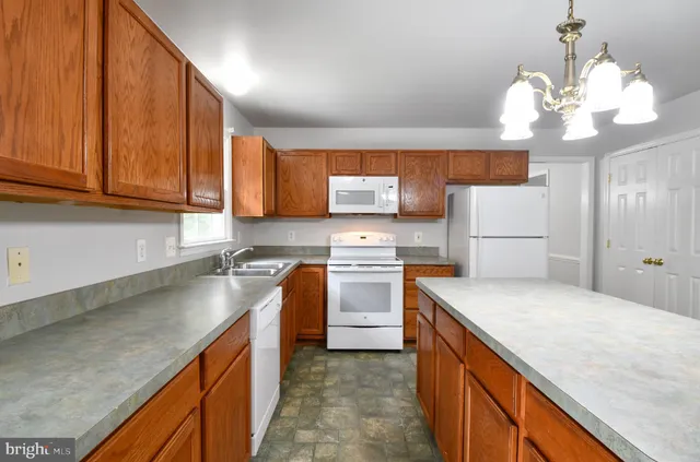 a kitchen with stainless steel appliances granite countertop a sink a stove and a refrigerator