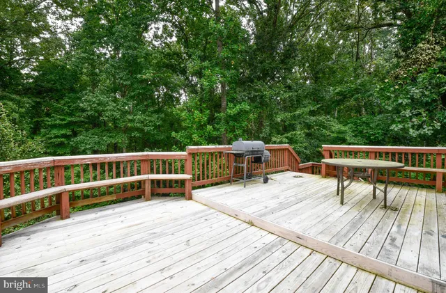 a view of a deck with chairs a barbeque with wooden floor and fence