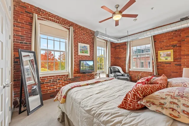 a bedroom with a bed and a large window