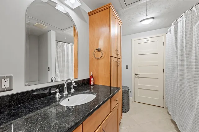 a bathroom with a granite countertop sink and a mirror