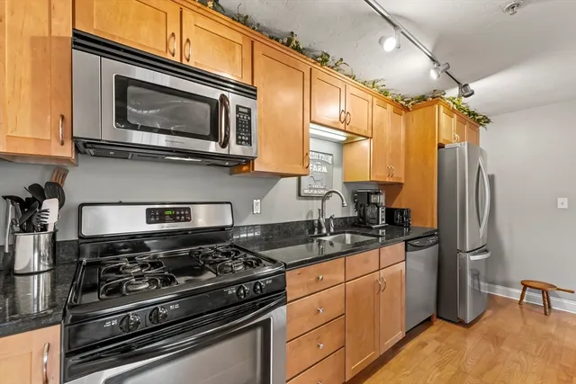 a kitchen with stainless steel appliances granite countertop a stove a sink and a microwave