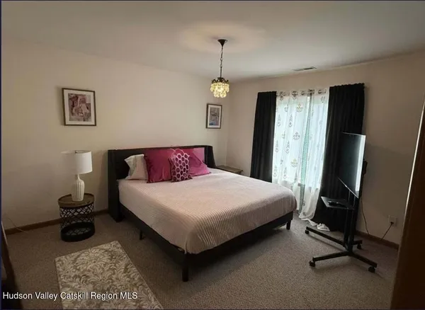 a view of a workspace with furniture and a window