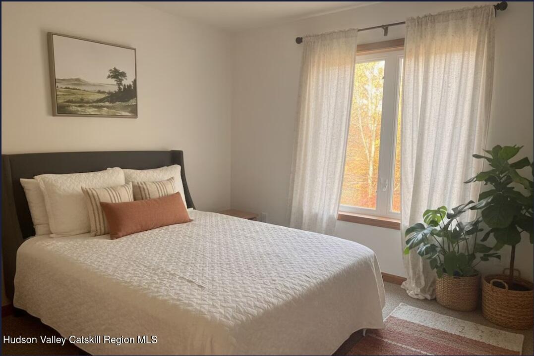 614 Salls Road New Lebanon, NY 12029 - Photo 16 of 22 a large bed sitting in a bedroom next to a window and a potted plant