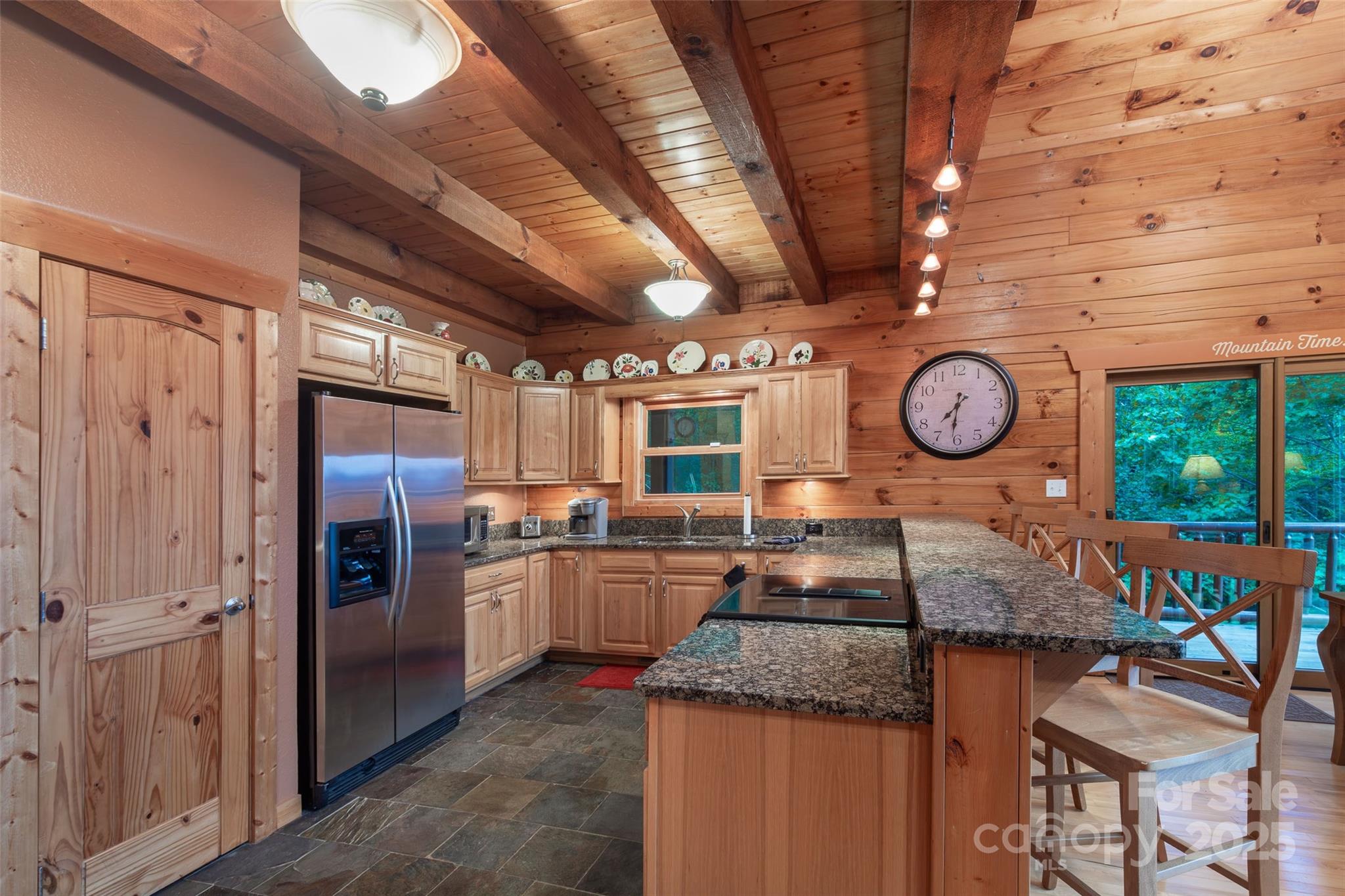 776 Still Branch Road Sylva, NC 28779 - Photo 15 of 43 a kitchen with stainless steel appliances granite countertop a stove top oven a clock and cabinets