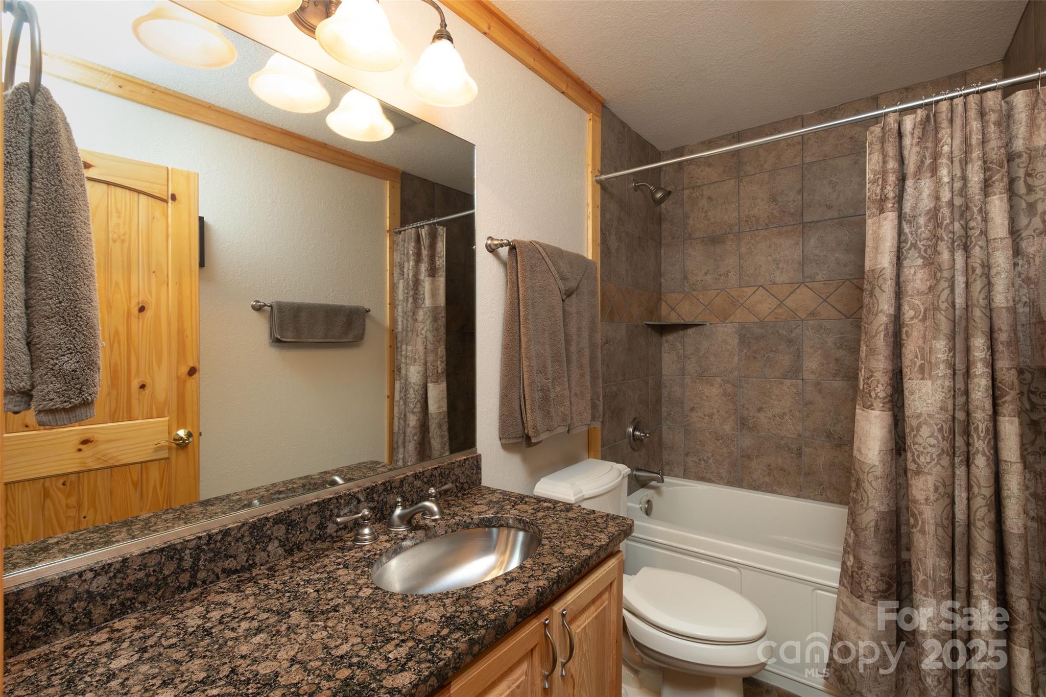 776 Still Branch Road Sylva, NC 28779 - Photo 29 of 43 a bathroom with a granite countertop sink toilet and shower