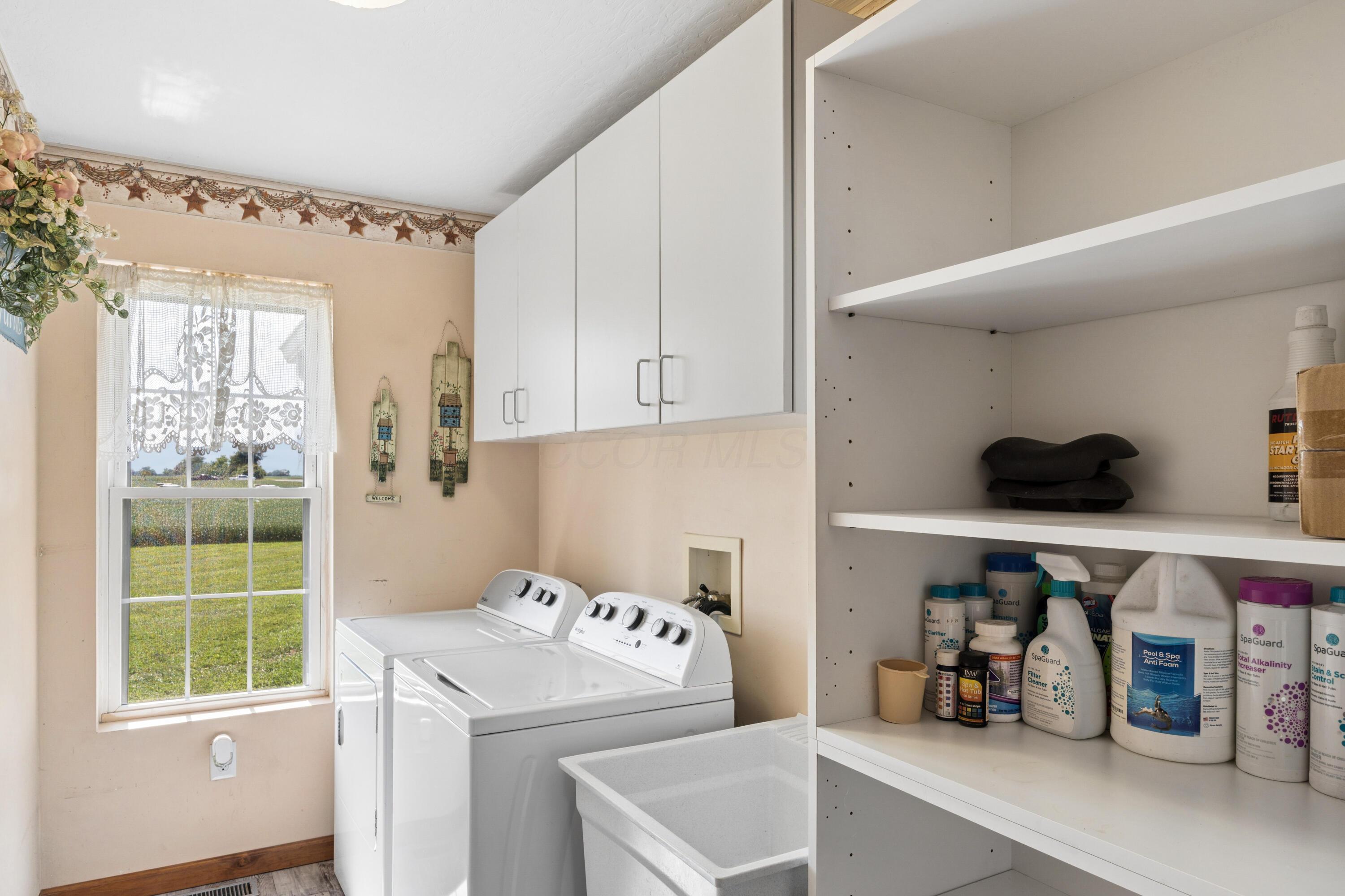 18964 London Road Circleville, OH 43113 - Photo 31 of 57 Laundry area featuring overhead cabinetry, built-in shelving, and a window with natural light