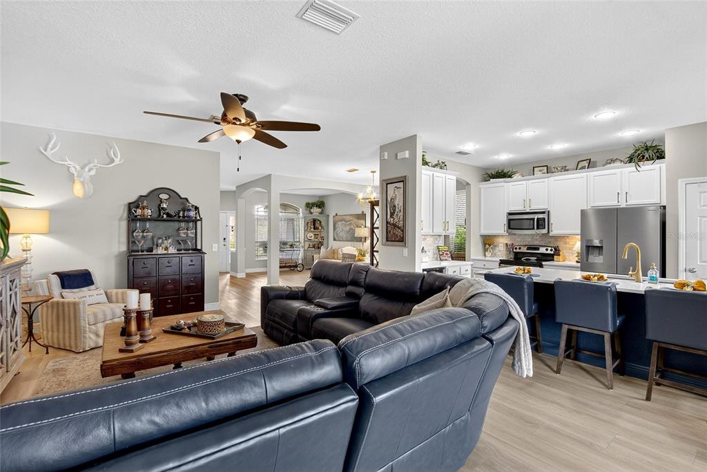 306 Hope Bay Loop Apollo Beach, FL 33572 - Photo 18 of 53 a living room with furniture kitchen view and a chandelier