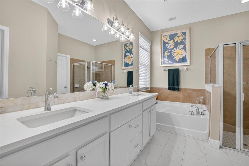 306 Hope Bay Loop Apollo Beach, FL 33572 - Photo 22 of 53 a bathroom with a sink double vanity granite tub shower and a mirror