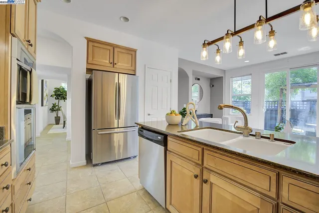 a kitchen with stainless steel appliances granite countertop a refrigerator and a sink