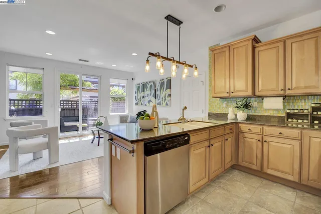 a kitchen with counter top space sink stove and wooden floor