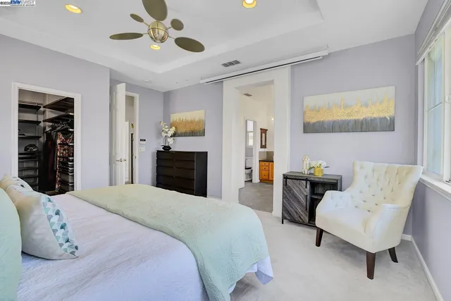 a spacious bedroom with a bed and a chandelier