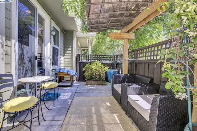 a view of a patio with table and chairs potted plants with wooden floor and fence