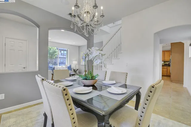 a view of a dining room with furniture a chandelier and wooden floor