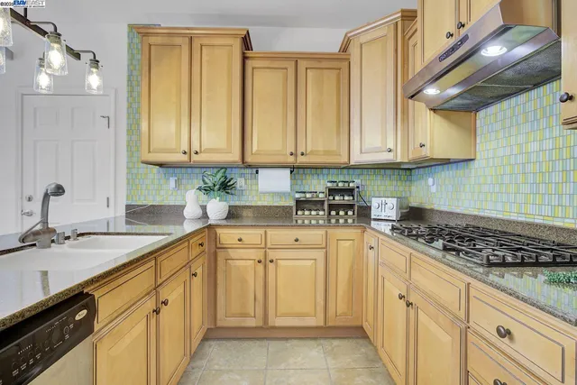 a kitchen with stainless steel appliances granite countertop a sink stove and cabinets