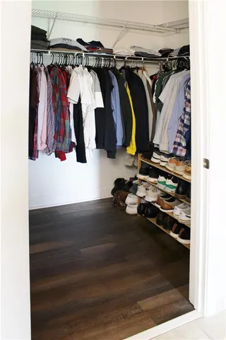 a view of walk in closet with clothes and shoes