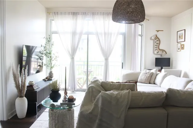 a living room with furniture fireplace and large windows