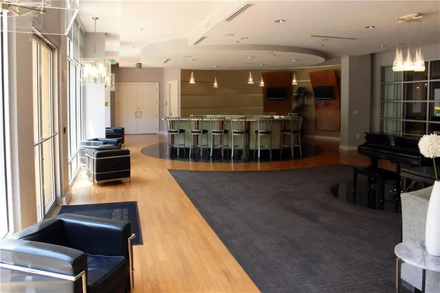 a kitchen with stainless steel appliances a stove a refrigerator a dining table and chairs with wooden floor