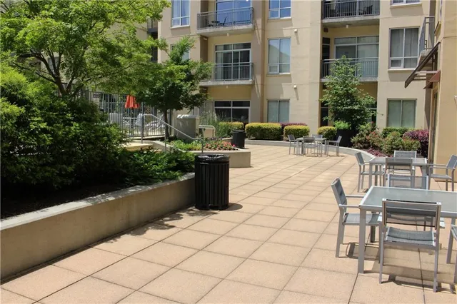 a view of a patio with dining table and chairs with potted plants