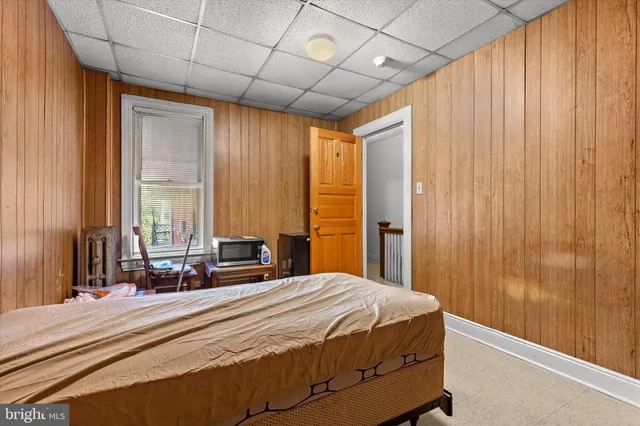 a bedroom with a bed and a large window