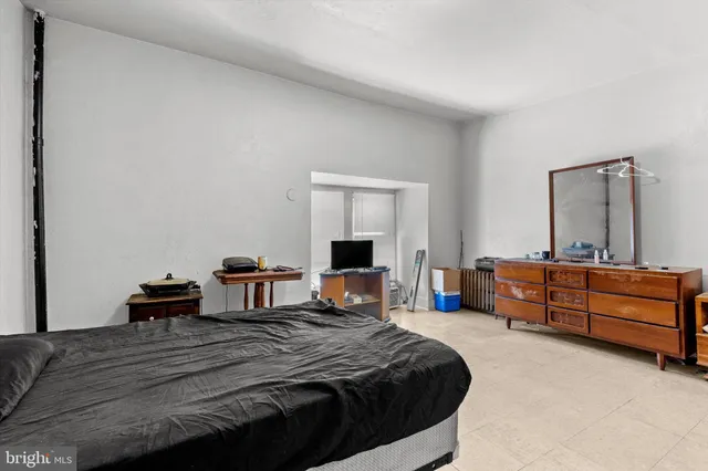 a bedroom with a bed and a mirror on dresser