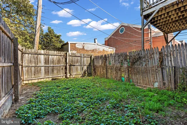 a view of a backyard with wooden fence