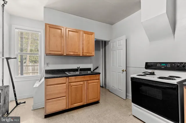 a kitchen with granite countertop a stove and a sink