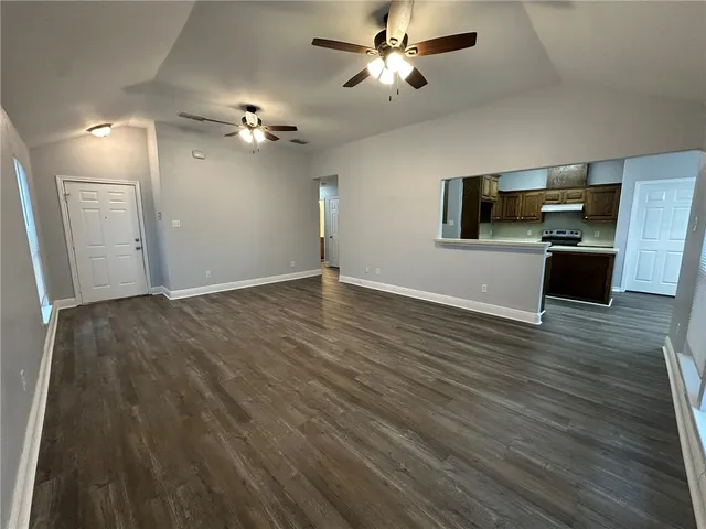 a view of a livingroom with a flat screen tv ceiling fan and hardwood floor