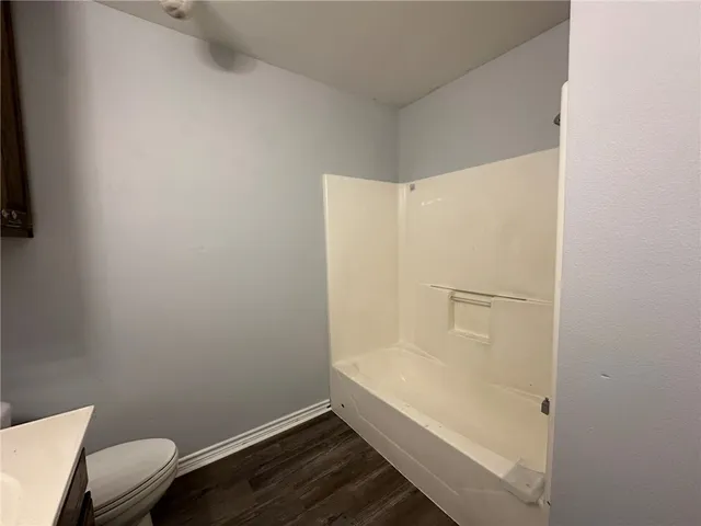 a bathroom with a granite countertop toilet and a bathtub