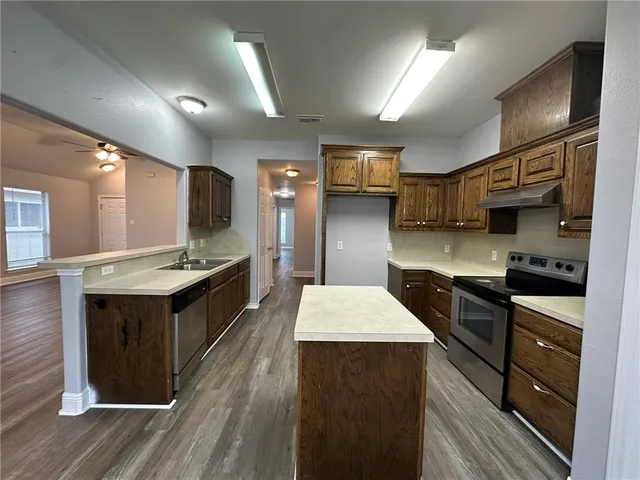 a kitchen with stainless steel appliances a sink stove and refrigerator
