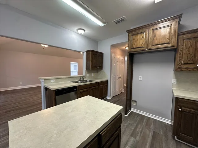 a kitchen with kitchen island a counter space a sink appliances and cabinets
