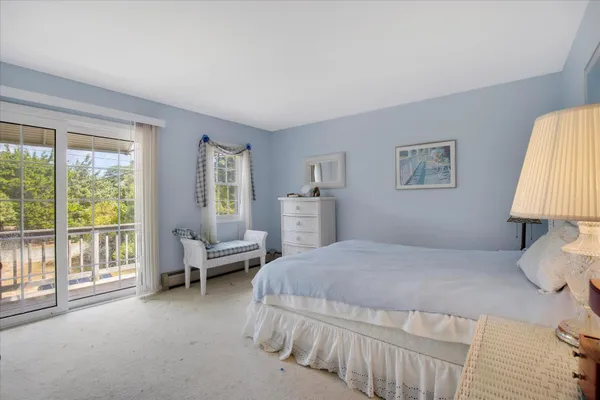 a bedroom with a bed and a lamp on dresser