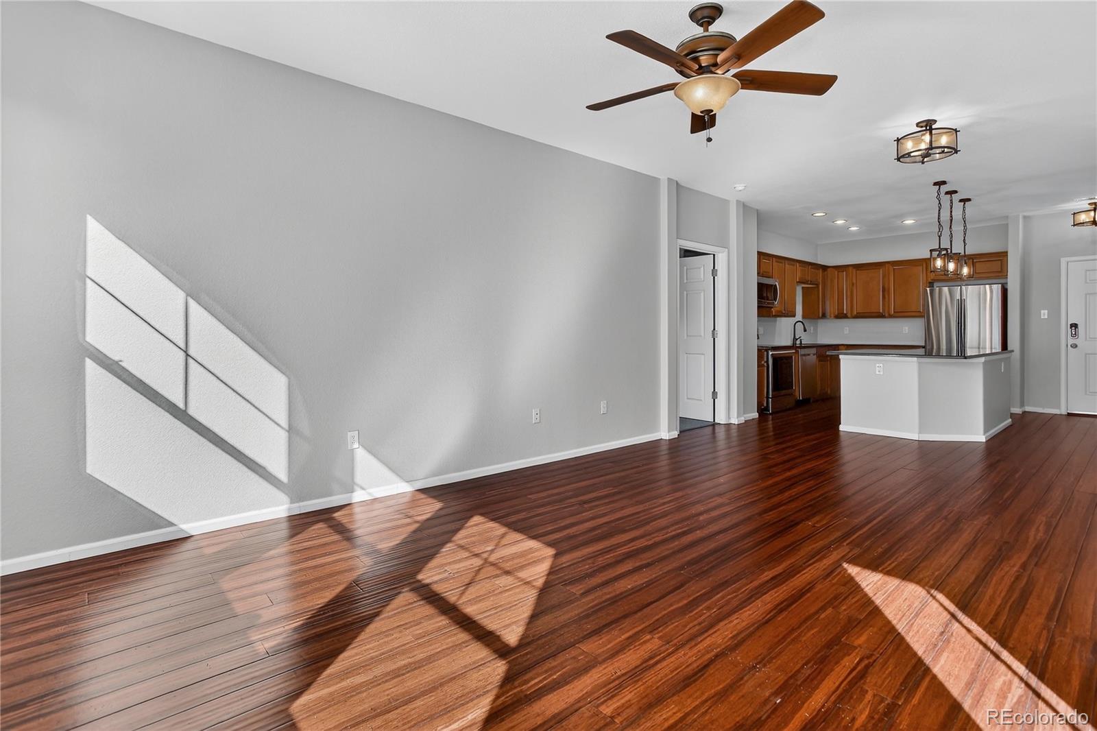 9633 East 5th Avenue, Unit 10208 Denver, CO 80230 - Photo 14 of 47 a view of a kitchen with wooden floor and a ceiling fan