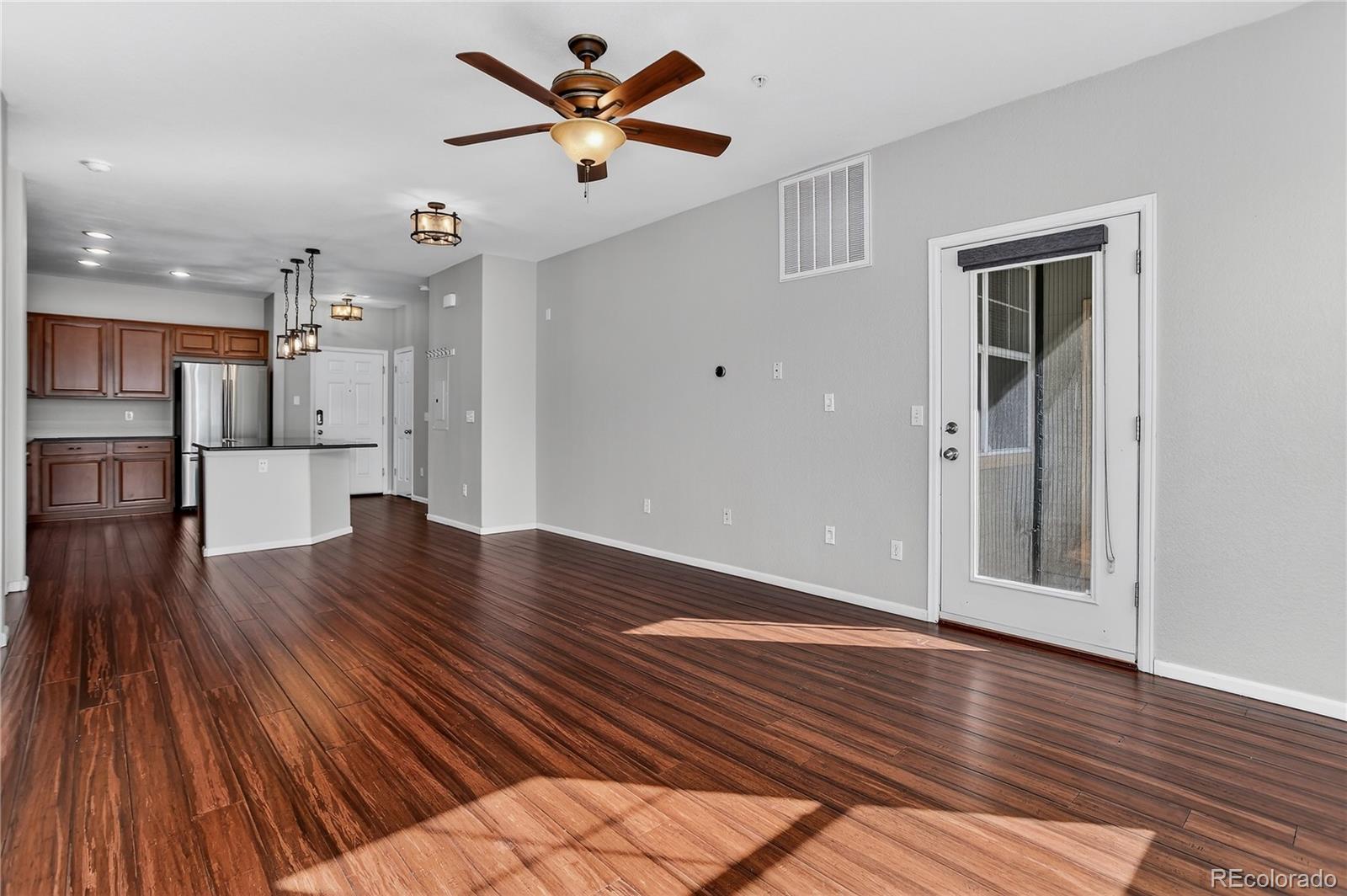 9633 East 5th Avenue, Unit 10208 Denver, CO 80230 - Photo 17 of 47 an empty room with wooden floor and a kitchen space