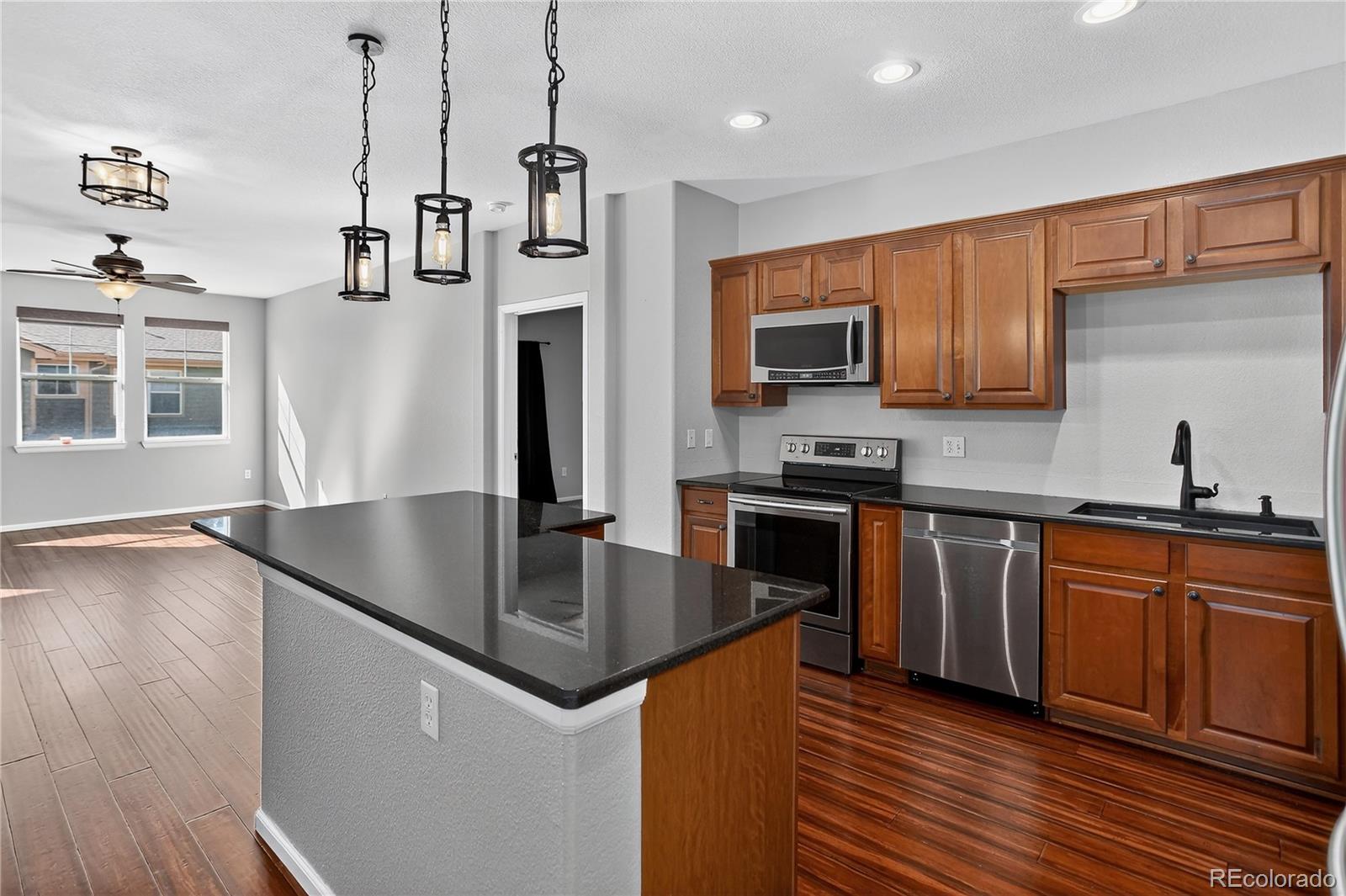 9633 East 5th Avenue, Unit 10208 Denver, CO 80230 - Photo 5 of 47 a kitchen with stainless steel appliances granite countertop a sink a stove and a refrigerator