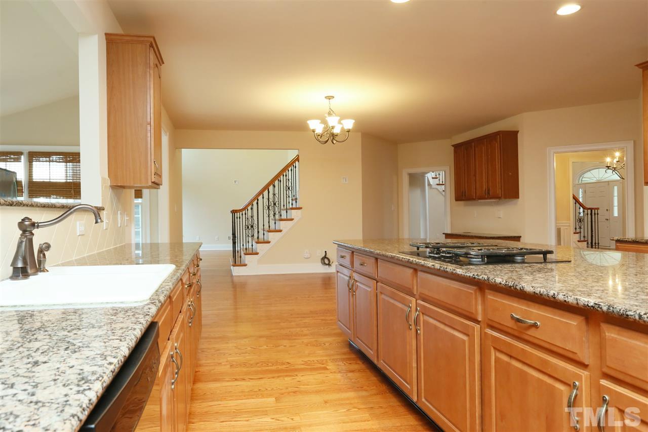 9505 Bluemont Court Raleigh, NC 27617 - Photo 12 of 25 a large kitchen with kitchen island granite countertop a sink and a stove